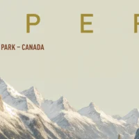 Close-up of snow-dusted pines and layered terrain around alpine lake